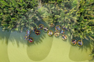 FEATURE -  Touristen in Booten durch Palmenwälder in Vietnam