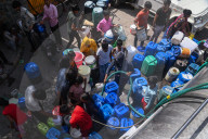 People fill water containers from a municipal water tanker in New Delhi, India - 13 Jun 2024