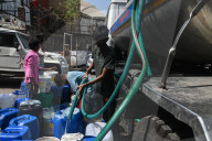 People fill water containers from a municipal water tanker in New Delhi, India - 13 Jun 2024