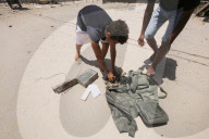 Palestinian youth lose some equipment and empty ammunition left by the Israeli army in along a street in the western part of Rafah, Rafah, Gaza Strip, Palestinian Territory - 14 Jun 2024