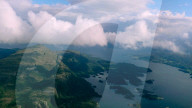 Aerial view through the clouds to the sea bay with coastal hills. Top view from the clouds to the Norwegian fjords, Norway - 15 Jun 2024