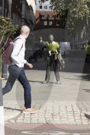 Campaigners tie baby slings to statues in call for better UK paternity leave.