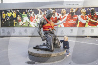 Campaigners tie baby slings to statues in call for better UK paternity leave.