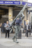 Campaigners tie baby slings to statues in call for better UK paternity leave.