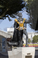 Campaigners tie baby slings to statues in call for better UK paternity leave.
