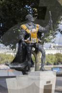 Campaigners tie baby slings to statues in call for better UK paternity leave.