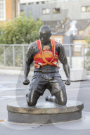 Campaigners tie baby slings to statues in call for better UK paternity leave.