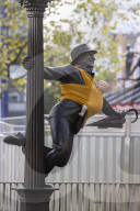 Campaigners tie baby slings to statues in call for better UK paternity leave.