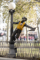 Campaigners tie baby slings to statues in call for better UK paternity leave.
