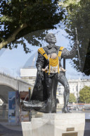 Campaigners tie baby slings to statues in call for better UK paternity leave.