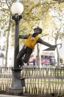 Campaigners tie baby slings to statues in call for better UK paternity leave.