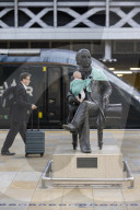 Campaigners tie baby slings to statues in call for better UK paternity leave.
