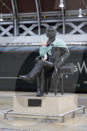 Campaigners tie baby slings to statues in call for better UK paternity leave.