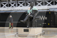 Campaigners tie baby slings to statues in call for better UK paternity leave.