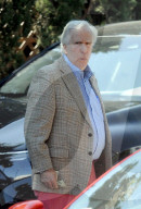 Henry Winkler, 78, gazes at his own memoir and carries a bag with the image of the late Farrah Fawcett as he emerges from a two hour lunch at a fancy eatery in Beverly Hills