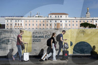 Turisti camminano lungo le delimitazioni dei cantieri per il Giubileo