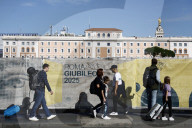 Turisti camminano lungo le delimitazioni dei cantieri per il Giubileo