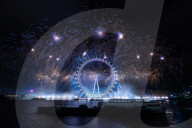 25th Anniversary of London’s New Year’s Eve fireworks display as seen from the RAF Memorial on the Embankment overlooking the river Thames towards the Coca-cola London Eye. 
31st December 2024