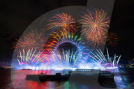 25th Anniversary of London’s New Year’s Eve fireworks display as seen from the RAF Memorial on the Embankment overlooking the river Thames towards the Coca-cola London Eye. 
31st December 2024