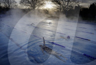 Swimmers brave cold temperatures to exercise in Hampton outdoor heated pool in south west London, UK. 