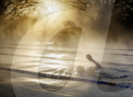 Swimmers brave cold temperatures to exercise in Hampton outdoor heated pool in south west London, UK. 