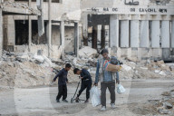 Palestinians amidst Gaza City rubble