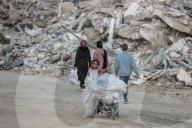 Palestinians amidst Gaza City rubble