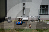 Senior Sunbathing In Berlin Backyard