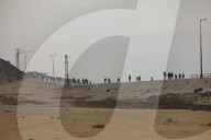 People walk along al-Rashid street between Gaza City and Nuseirat in the central Gaza Strip