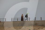 People walk along al-Rashid street between Gaza City and Nuseirat in the central Gaza Strip