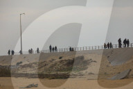 People walk along al-Rashid street between Gaza City and Nuseirat in the central Gaza Strip