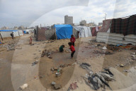 Gazans live in makeshift tents amidst building ruins