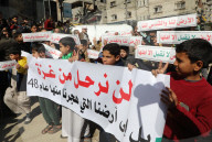 Palestinians including children, holding banners, gather in front of the Suheda Mosque to protest against U.S. President Donald Trump's