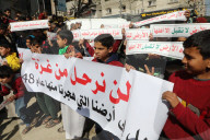 Palestinians including children, holding banners, gather in front of the Suheda Mosque to protest against U.S. President Donald Trump's