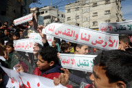 Palestinians including children, holding banners, gather in front of the Suheda Mosque to protest against U.S. President Donald Trump's
