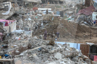 Palestinians walk past the rubble of destroyed buildings, amid a ceasefire between Israel and Hamas, in the Zeitoun neighborhood, south of Gaza City