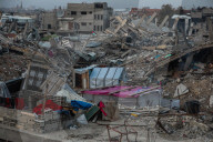 Palestinians walk past the rubble of destroyed buildings, amid a ceasefire between Israel and Hamas, in the Zeitoun neighborhood, south of Gaza City