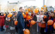 Orange balloons are released over Trafalgar Square in memory & honour of the Bibas family, London, UK.