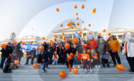 Orange balloons are released over Trafalgar Square in memory & honour of the Bibas family, London, UK.