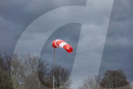 Windsock Indicating Strong Wind Under Dark Clouds