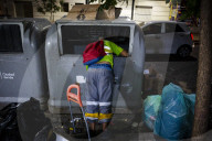 A Person Rummages Through A Trash Bin Looking For Food Or Something Valuable. Autonomous City Of Buenos Aires, Argentina.