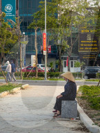 Two Women In Conical Hats Rest On A Bench In A Park In Vietnam