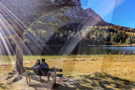 Couple Enjoying Sunlight By The Lake In Mittenwald