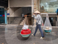 Woman Carries Food Using A Shoulder Pole In Hanoi