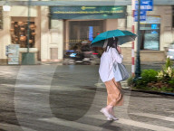 Woman Walks Across A Rainy Street In Central Hanoi