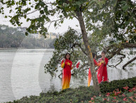 Women In Traditional Dresses At Hoan Kiem Lake In Hanoi