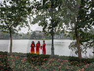 Women In Traditional Dresses At Hoan Kiem Lake In Hanoi