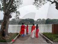 Women In Traditional Dresses At Hoan Kiem Lake In Hanoi