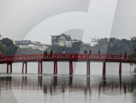 Tourists Crossing The Huc Bridge On Hoan Kiem Lake