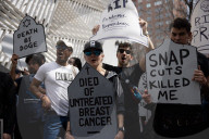 Activists Gather At NYC AIDS Memorial And March To Tesla Dealership For 38th Anniversary Of ACT UP To Protest DOGE Cuts